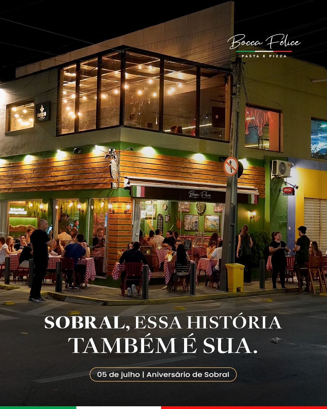 Fachada do Bocca Felice à noite, com mesas na calçada